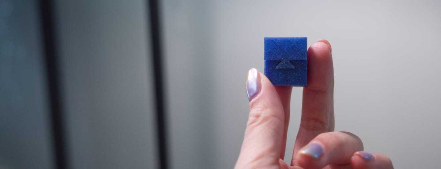 a photo of a a hand holding a small 3d-printed box testing fit tolerances