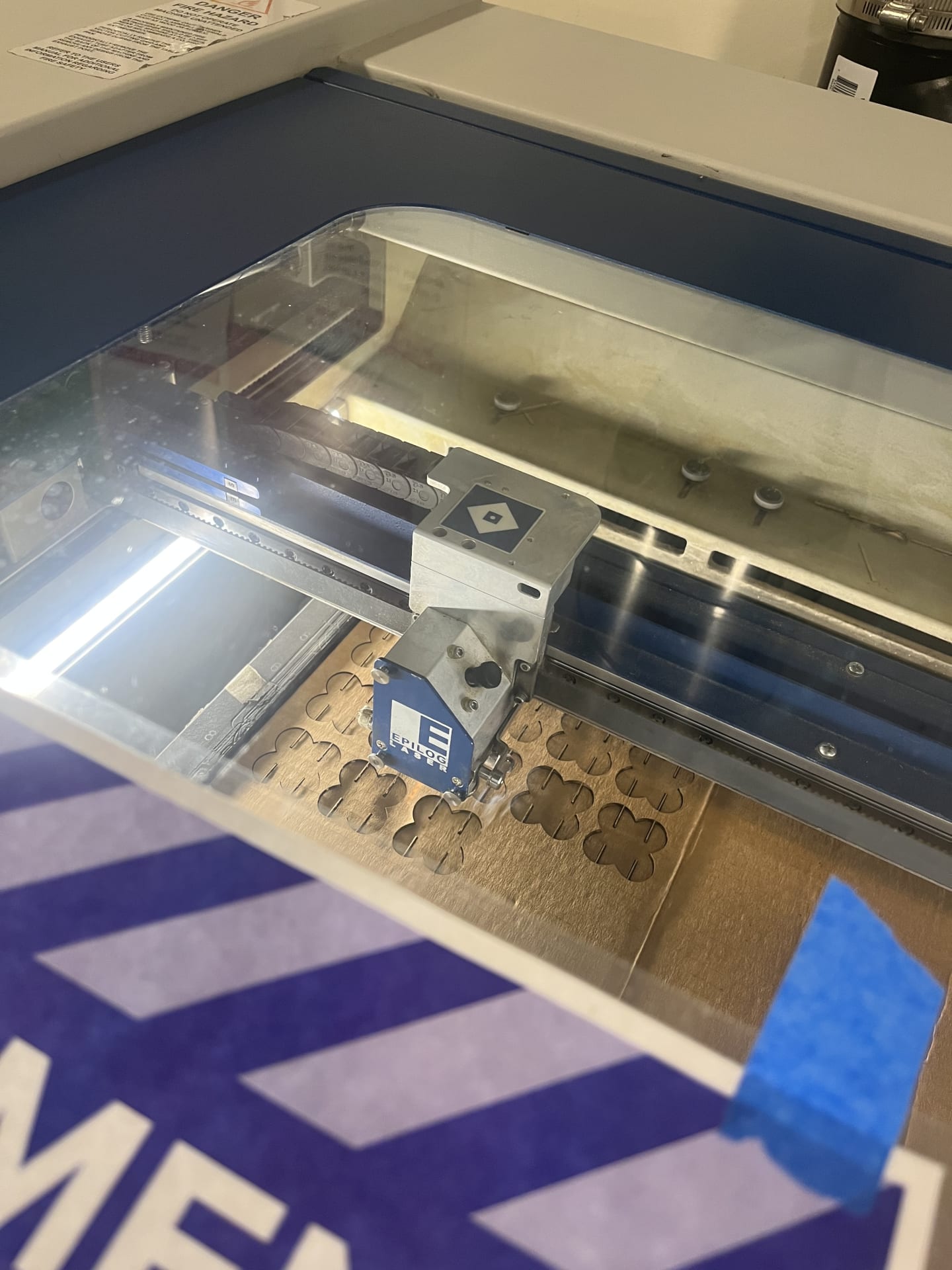 Photo of the laser cutter cutting the butterfly shapes mid-cut through the glass.