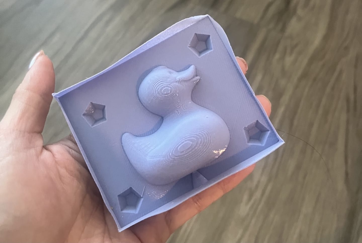 Photo of celina holding a finished cured purple duck mold that was a mold instead of a mold of a mold.