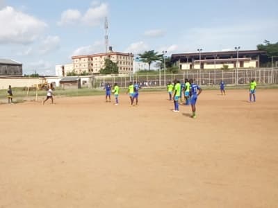 Match de football sur un terrain en terre battue