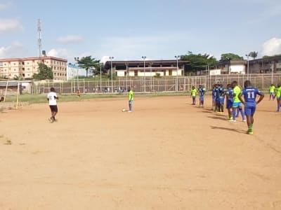 Match de football sur un terrain en terre battue