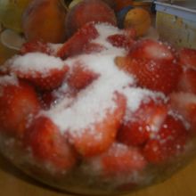 Erdbeeren mit Zucker bestreuen