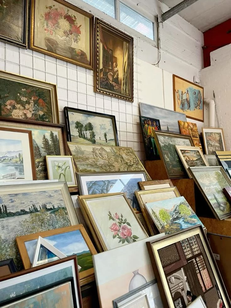 Estate sale paintings stacked against wall