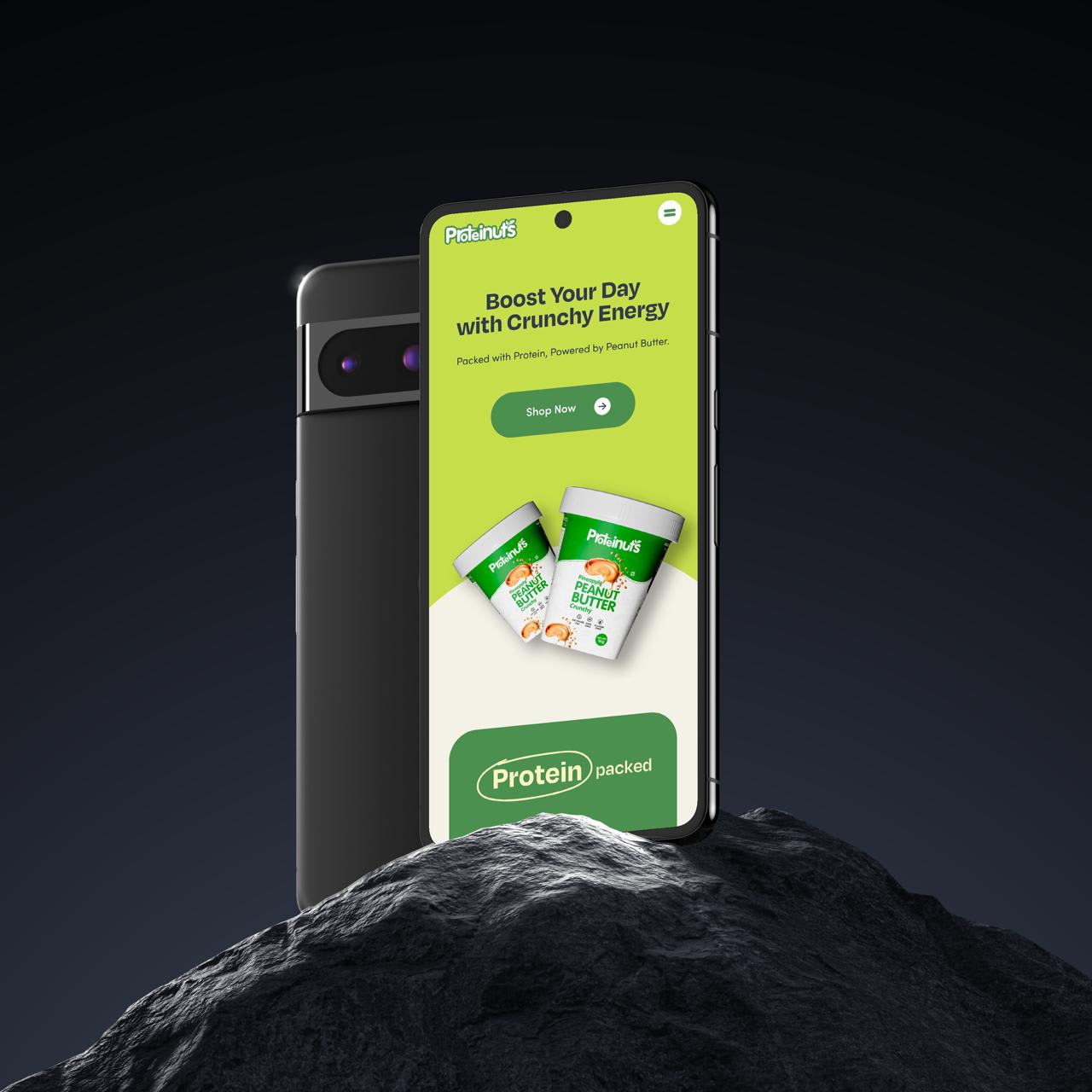 Proteinuts e-commerce site on a phone standing on rock