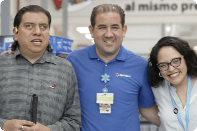 Three people smiling, standing together: one is blind, and two are Wal-Mart employees