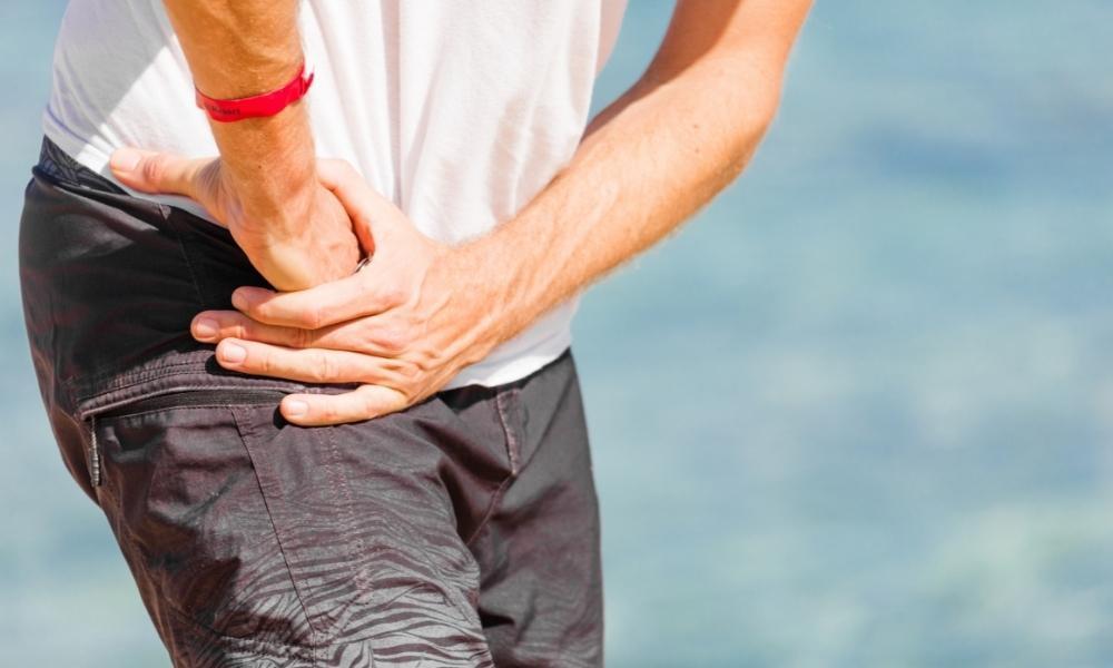 Person holding the front of the hip or groin area indicating pain