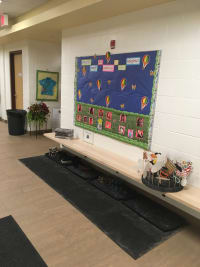 Shoe storage hall with a staff appreciation board that reads OKCC staff are soaring to new heights!
