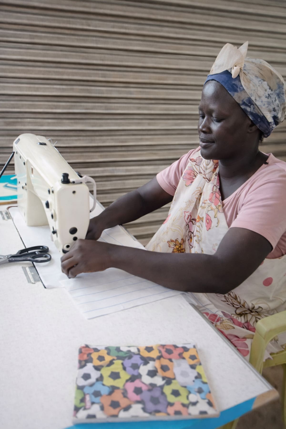Woman sewing with vibrant fabric swatch