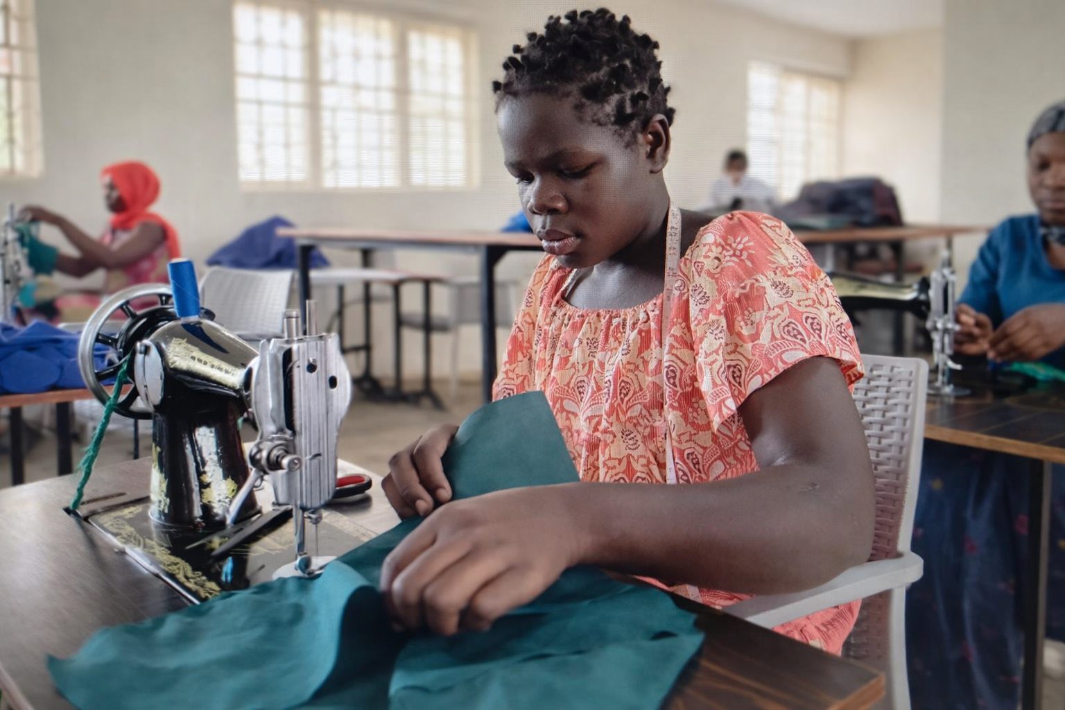 Young girl sewing in a classroom setting