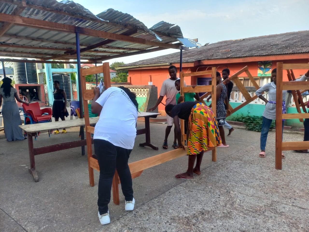 Volunteers assembling bunk beds in the courtyard