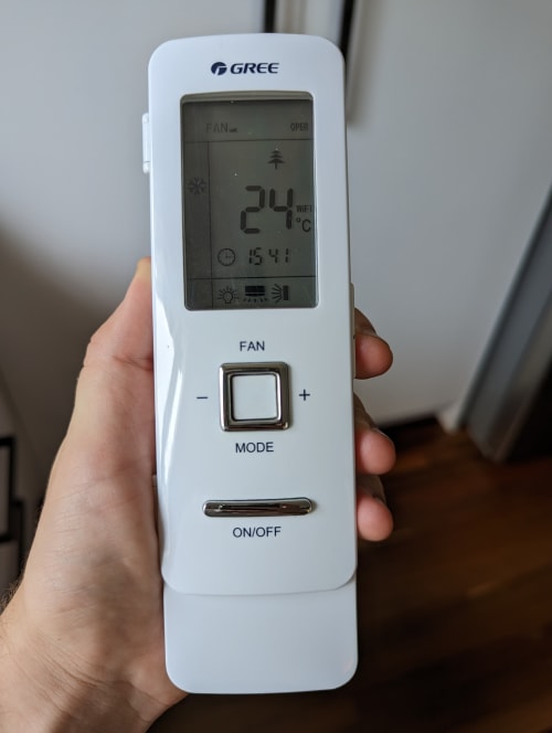 air conditioning remote with the flap closed, revealing only a a couple of buttons