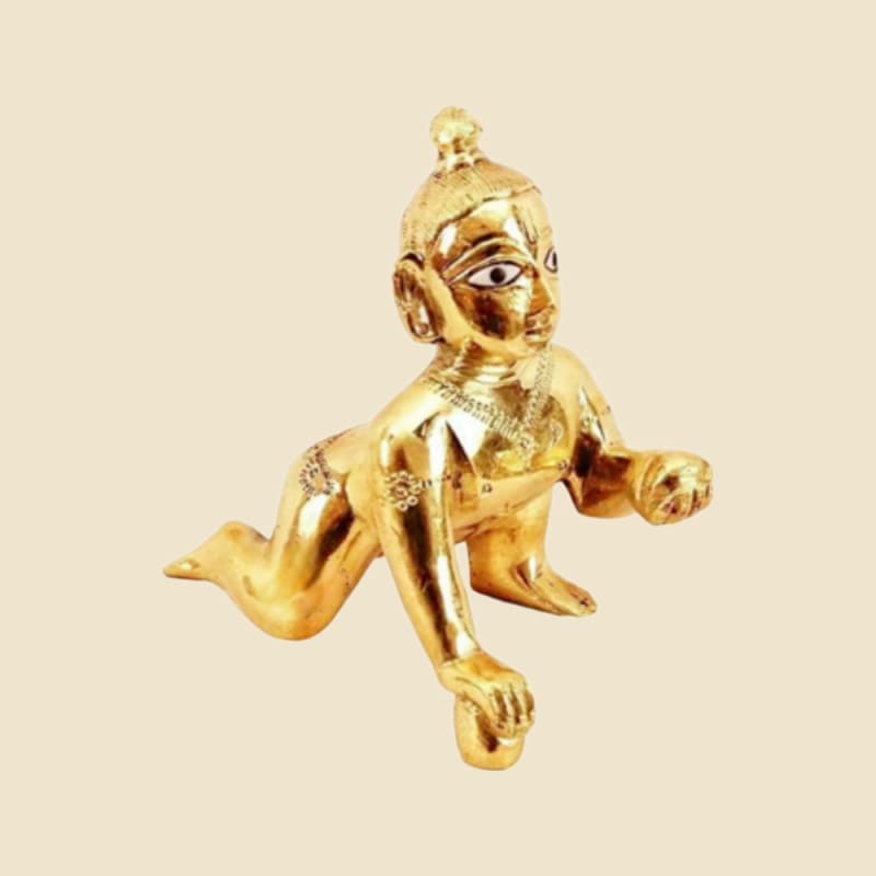 Polished Brass Laddu Gopal with Painted Eyes, Reaching Pose on a warm ivory background