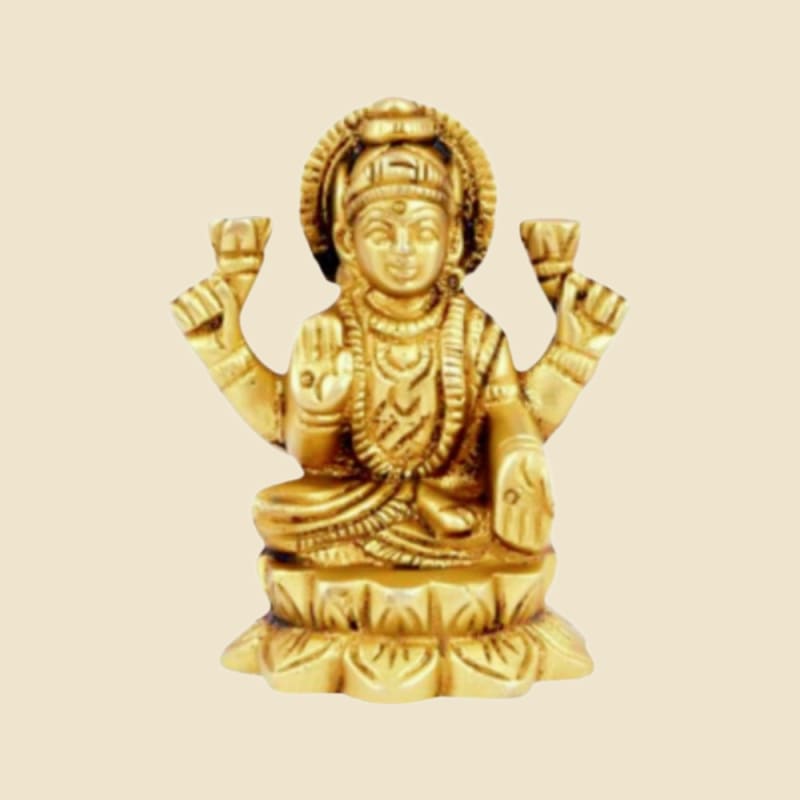 Bright-gold Brass Lakshmi on a warm ivory background