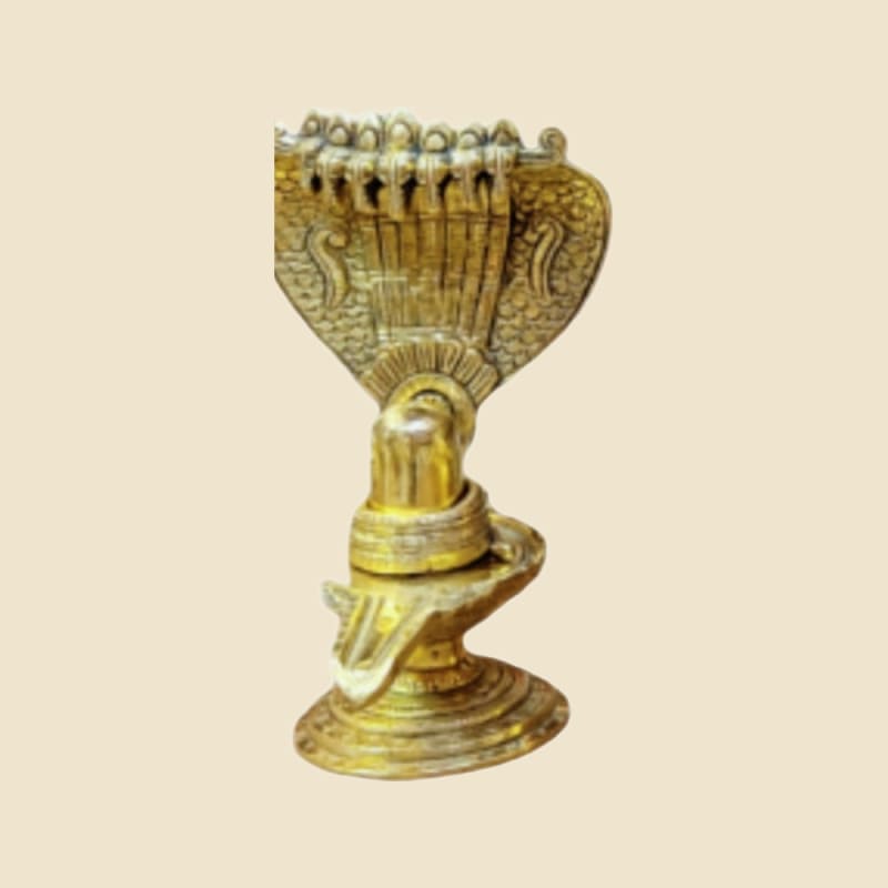 Brass Shivling with Serpent Hood on a warm ivory background
