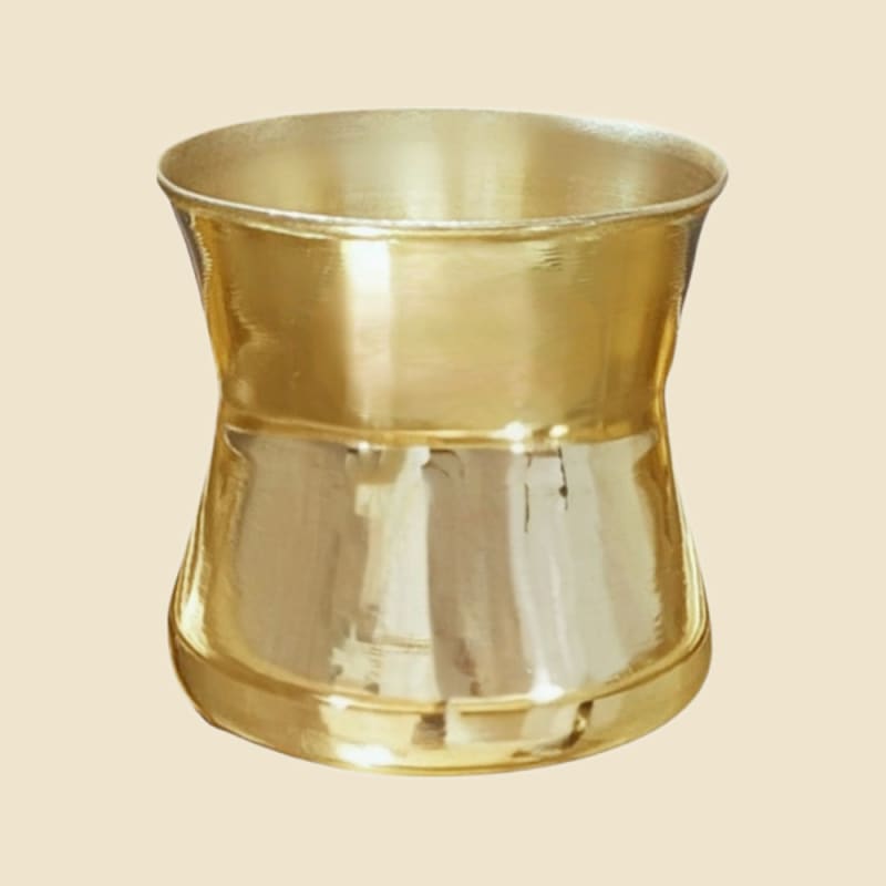 Brass Damru Panch Patra on a warm ivory background
