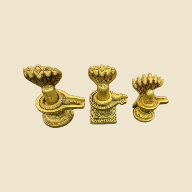 Brass Shivling with Sheshnag, Set of Sizes on a warm ivory background