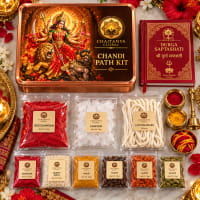 Close-up of Devi items — red chandan, thick wicks, Saptashati book