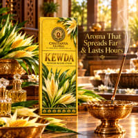 Kewda incense stick burning in a brass holder beside the slim box
