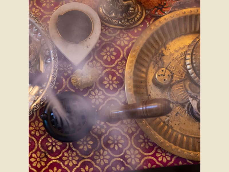 Loban burner smoking on a brass tray in a festive setting