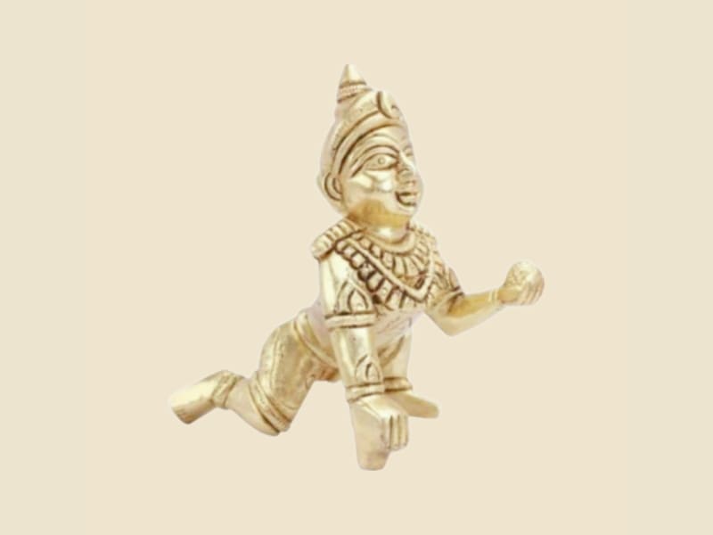 Brass Laddu Gopal with Crown, Antique Finish on a warm ivory background