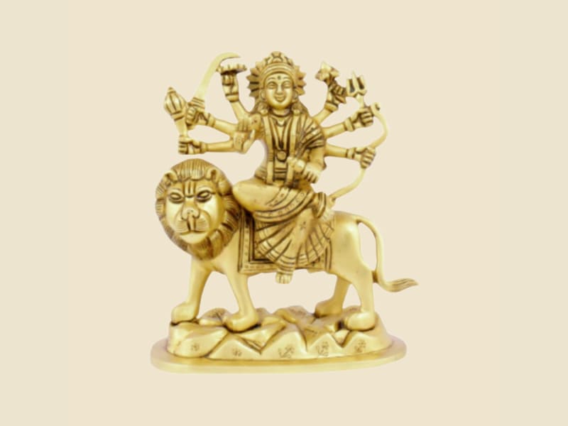 Brass Durga on Lion, Rock Base on a warm ivory background