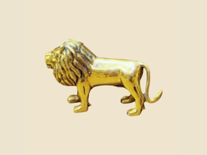 Brass Lion Figurine on a warm ivory background