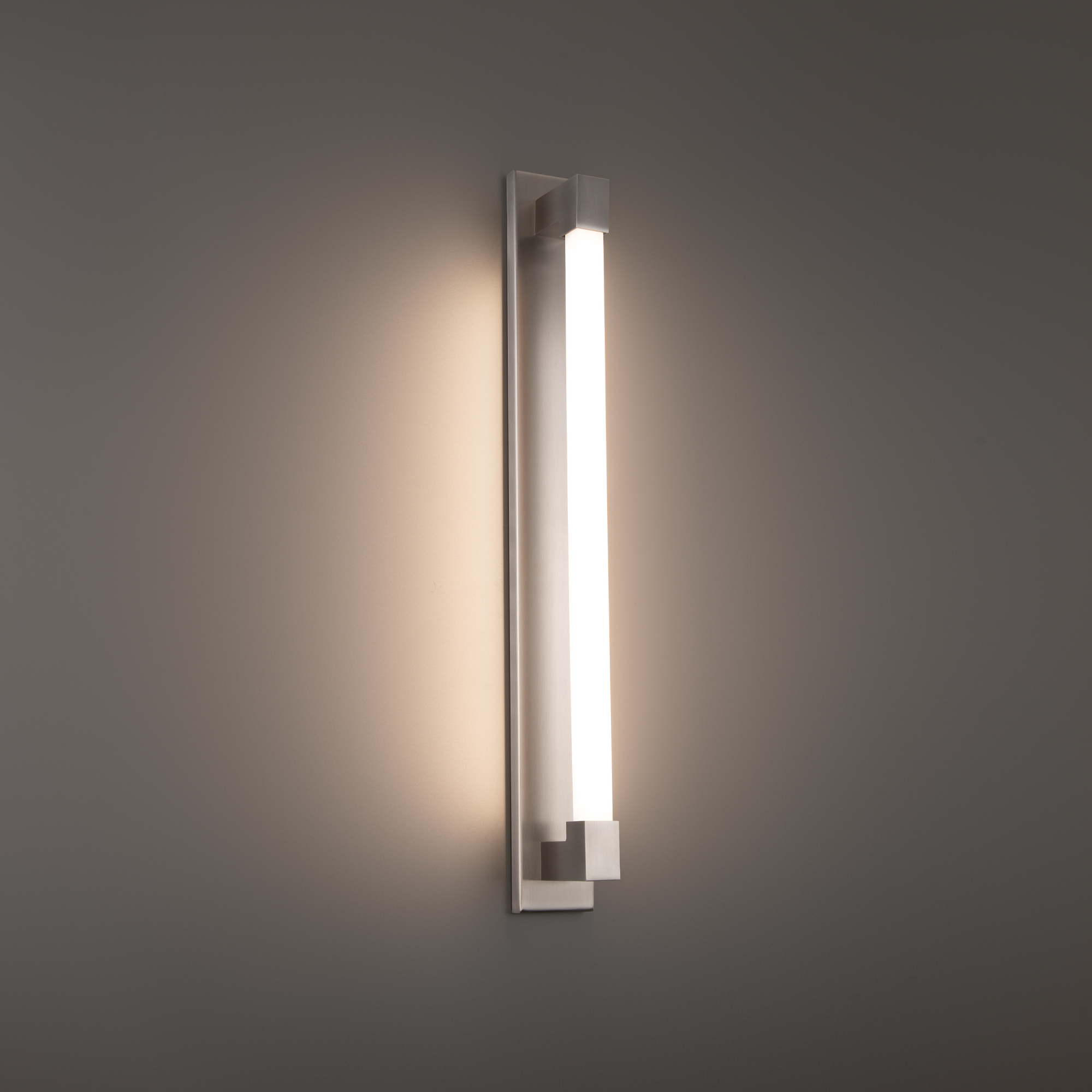 A minimalist yet bold bath luminaire that deploys robust, flattering illumination above or alongside a vanity in residential, hospitality and commercial environments.