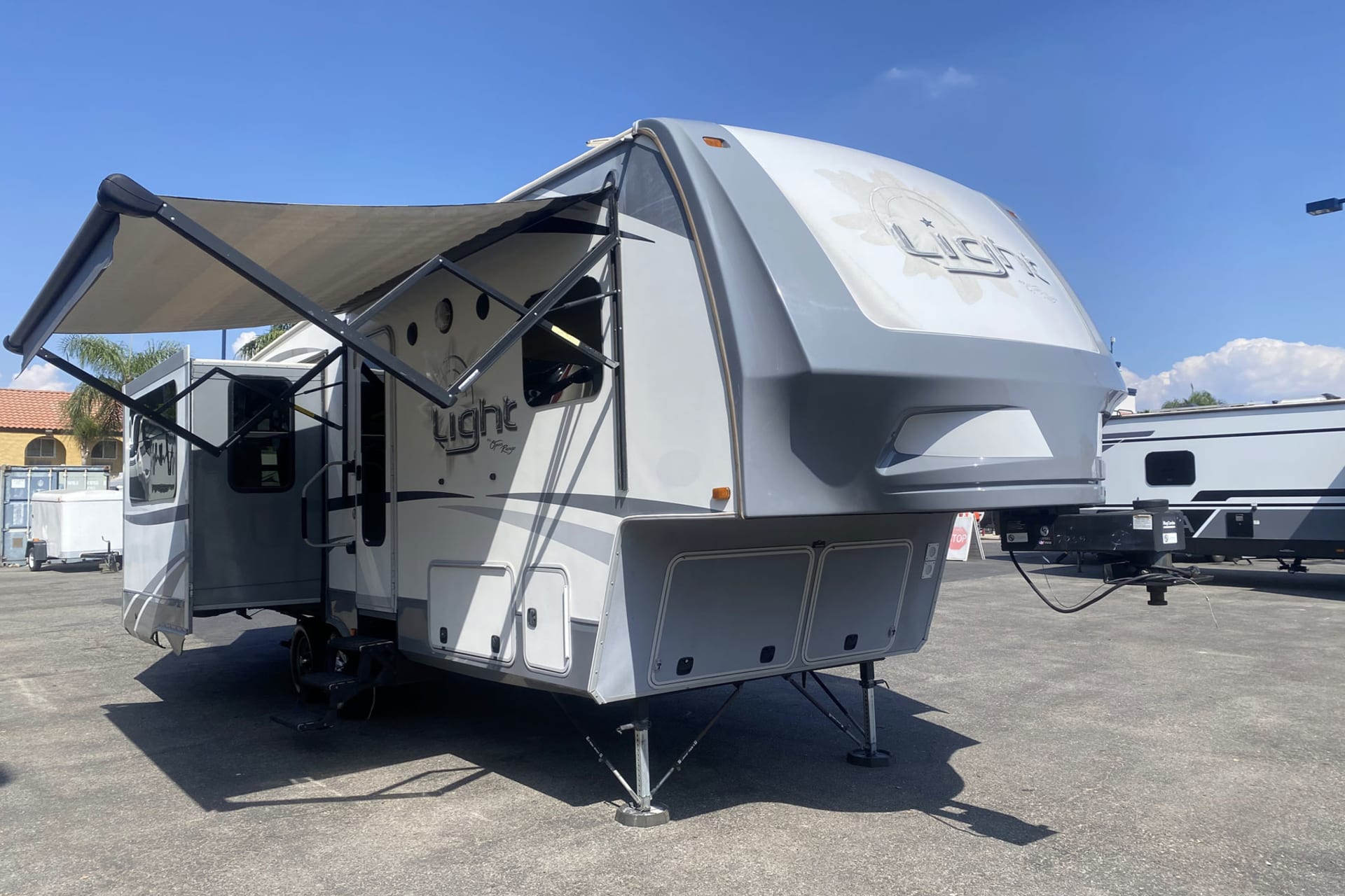 Outside front and passenger side view of a 2017 Highland Ridge Open Range Lite LF297RLS 5th wheel trailer RV