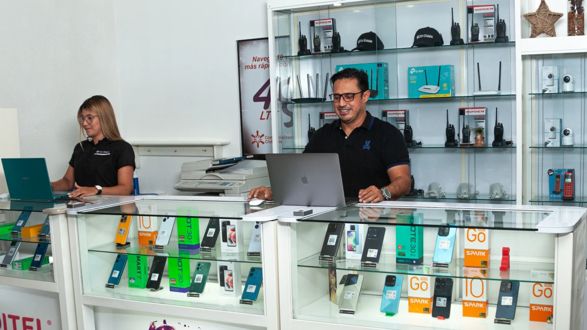 Nixon Perez el fundador de Grupo Globales y una representante de ventas en la vitrina de teléfonos de la tienda