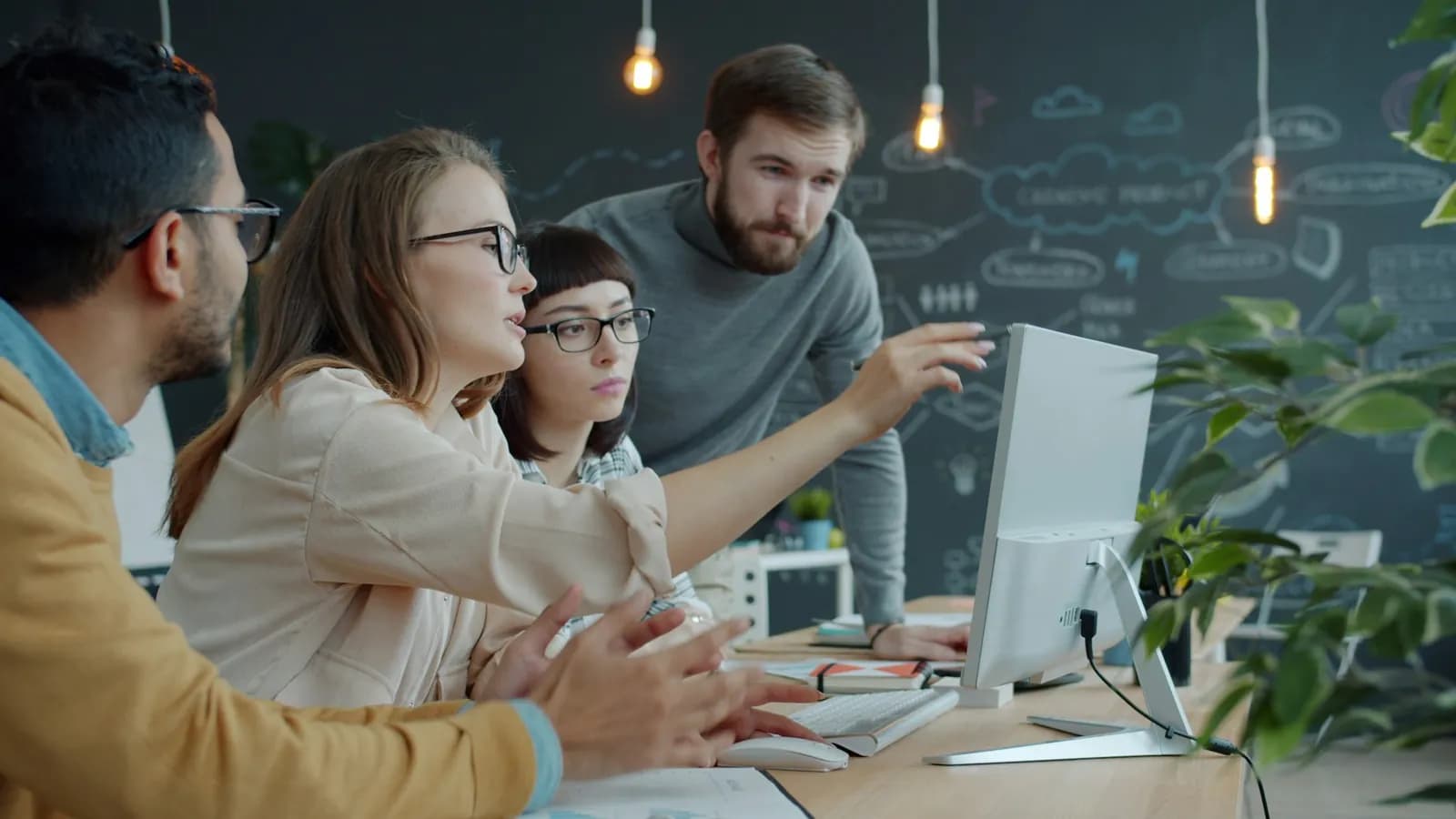 Équipe réunie autour d’un écran pour travailler sur un projet digital