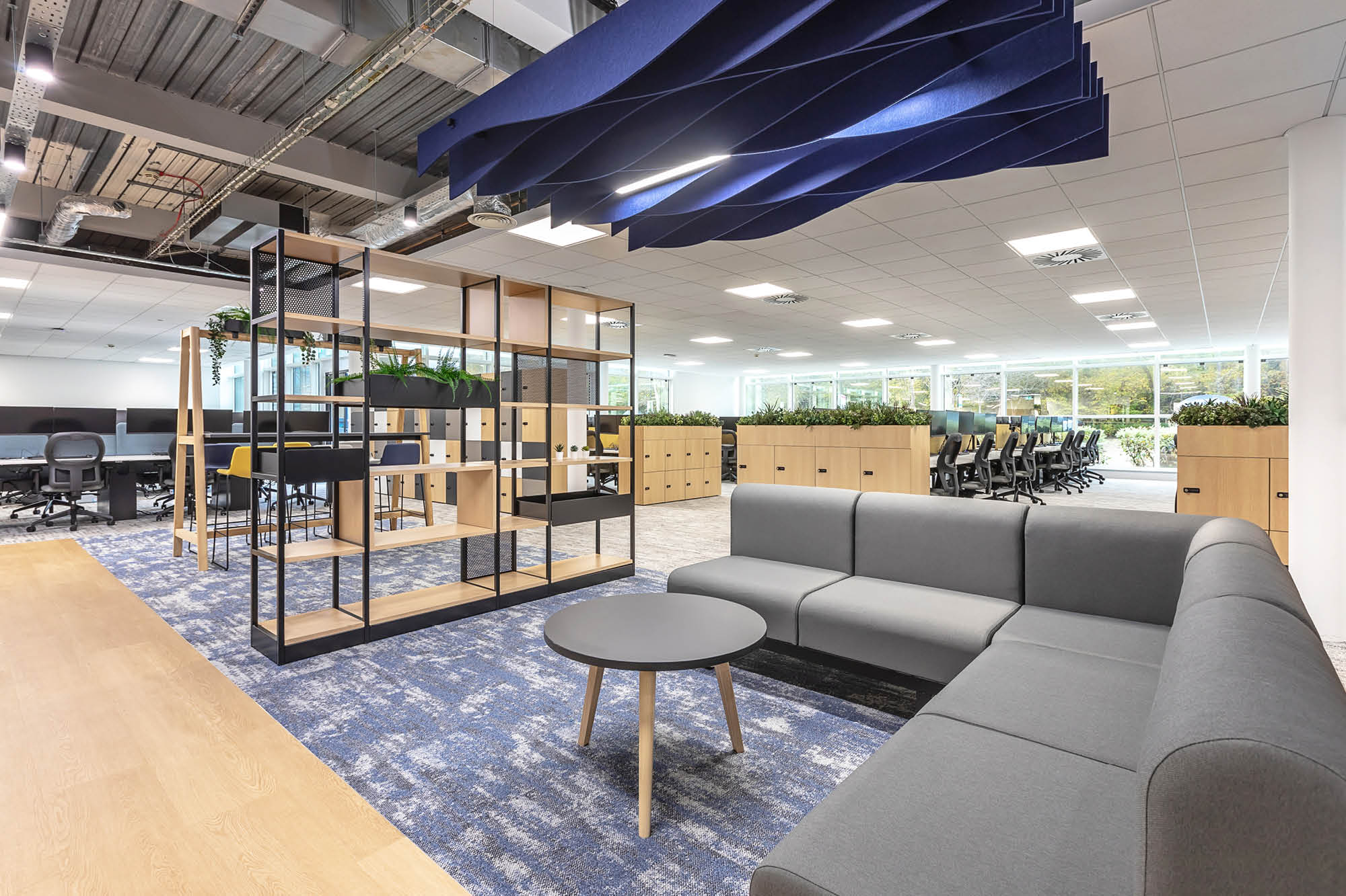 Circular light fixtures in office room with 4 black chairs and tanned carpet