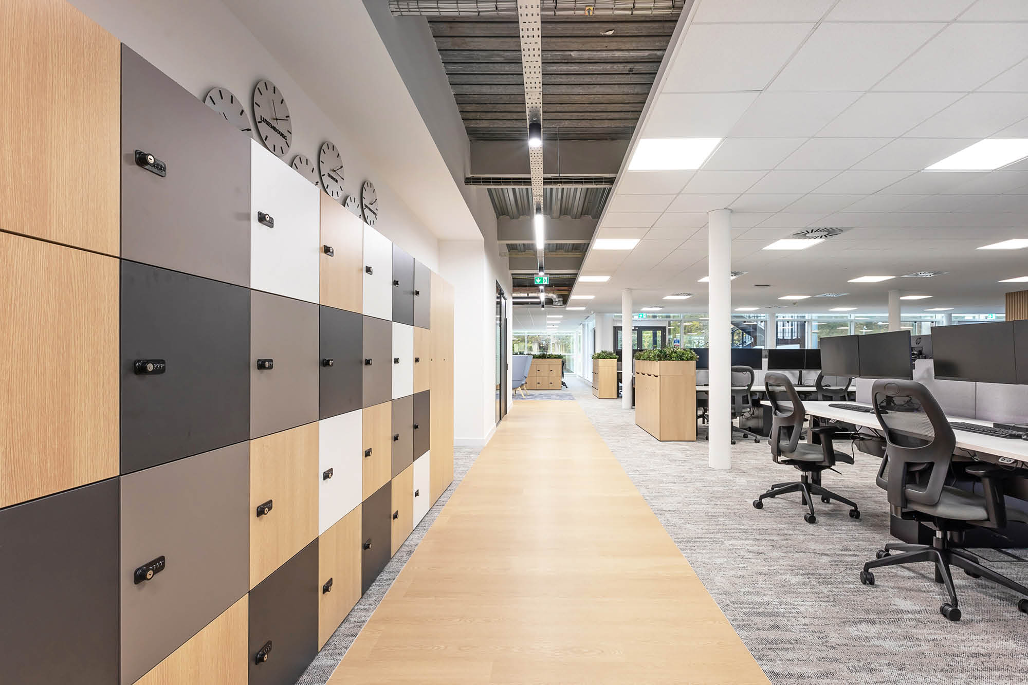 Modern office interior with row of lockers on the left, featuring a black, white, and wood pattern.