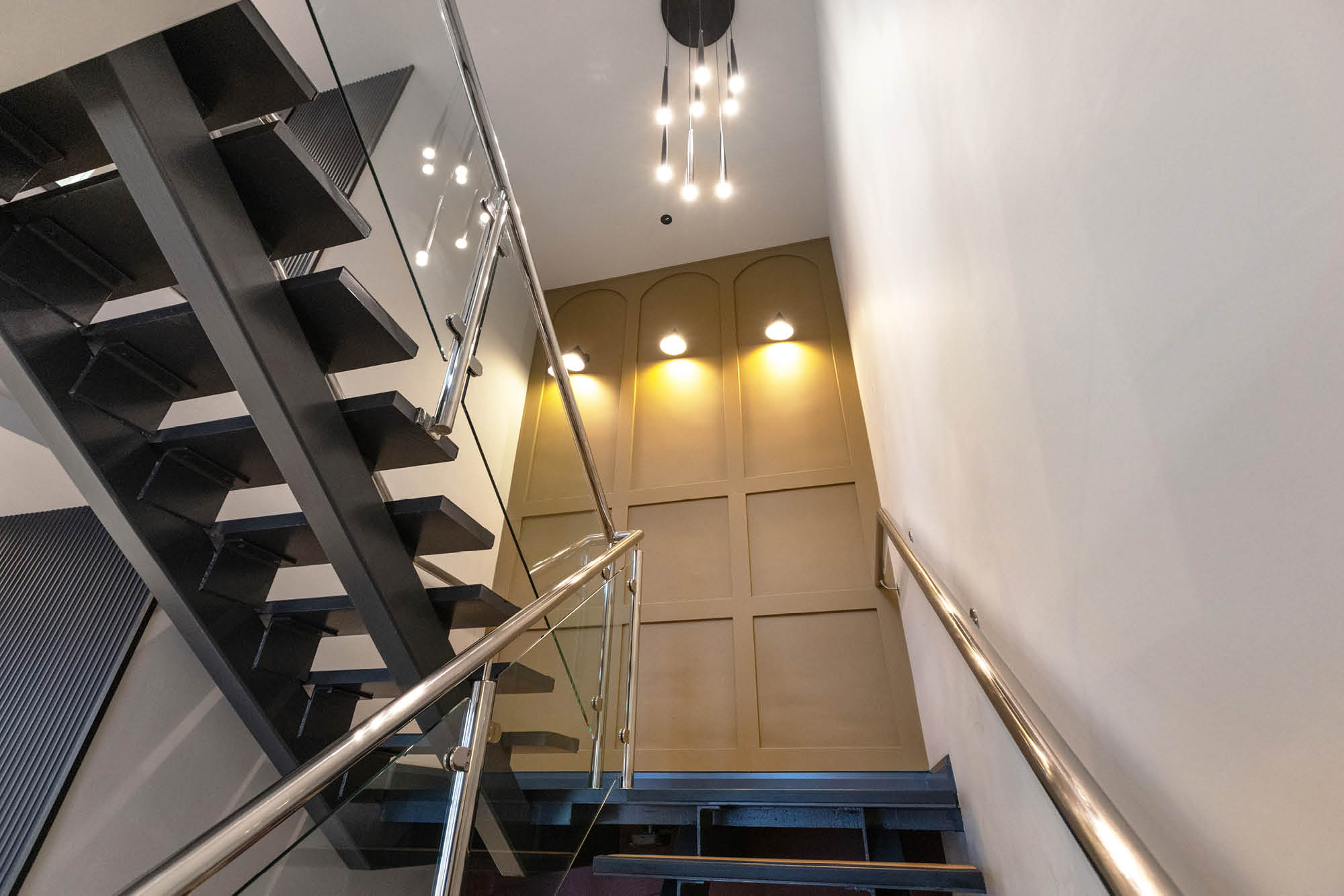 Modern staircase leading to an upper floor, with sleek metal railings and dark steps.
