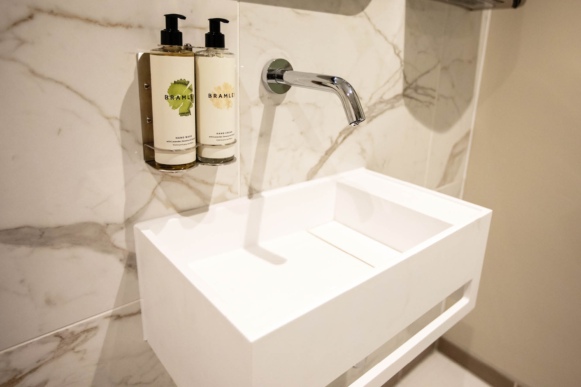 A modern bathroom with a sleek, white rectangular sink and wall-mounted chrome faucet.