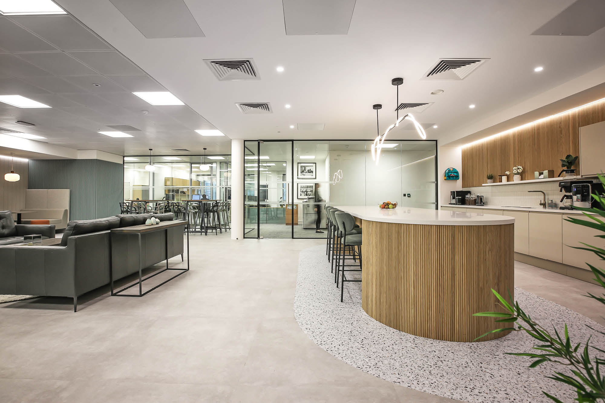 Modern open plan office design with breakfast bar and sofa seating area.