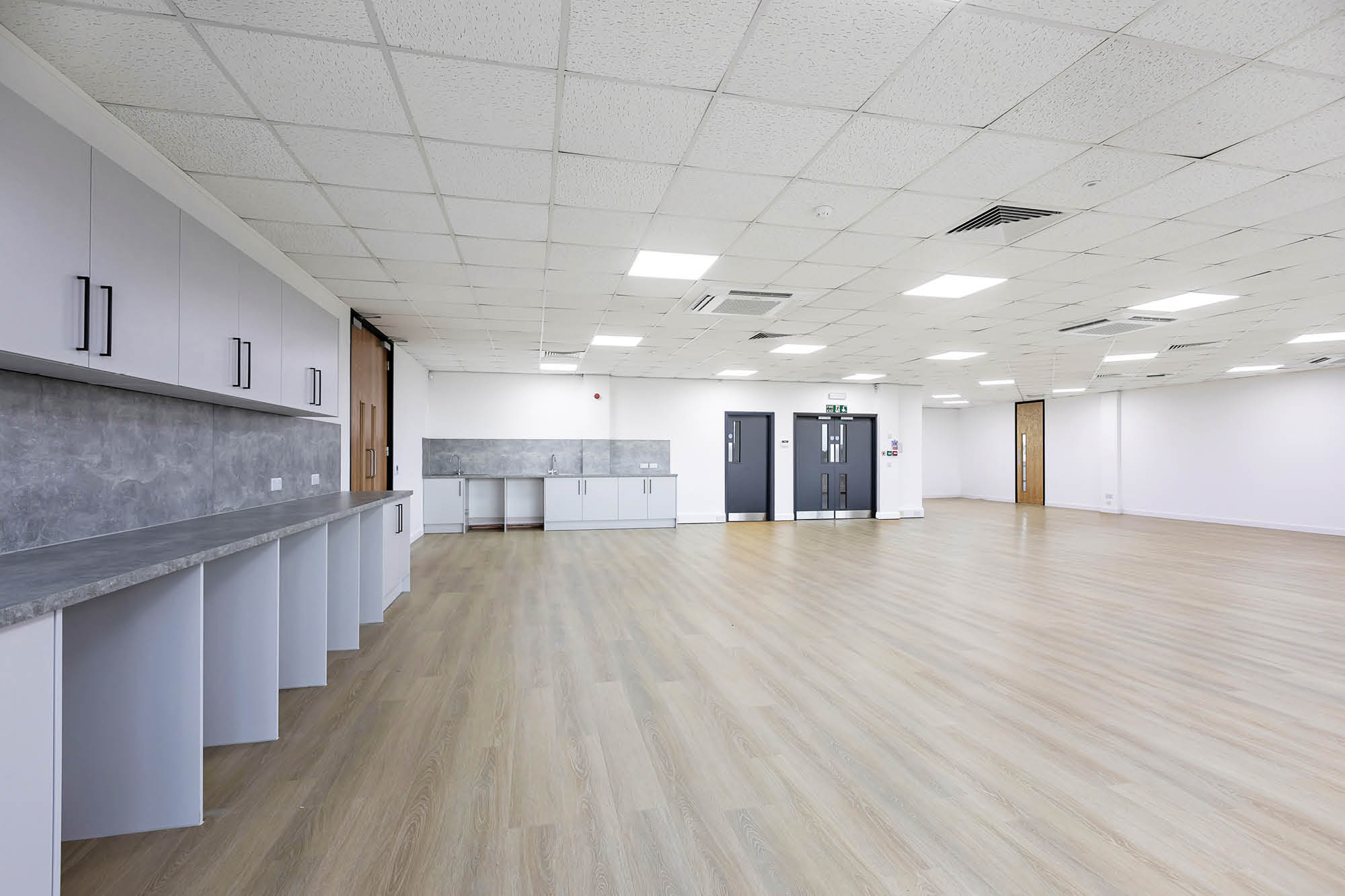 Laminate flooring in open office space and kitchen countertops.
