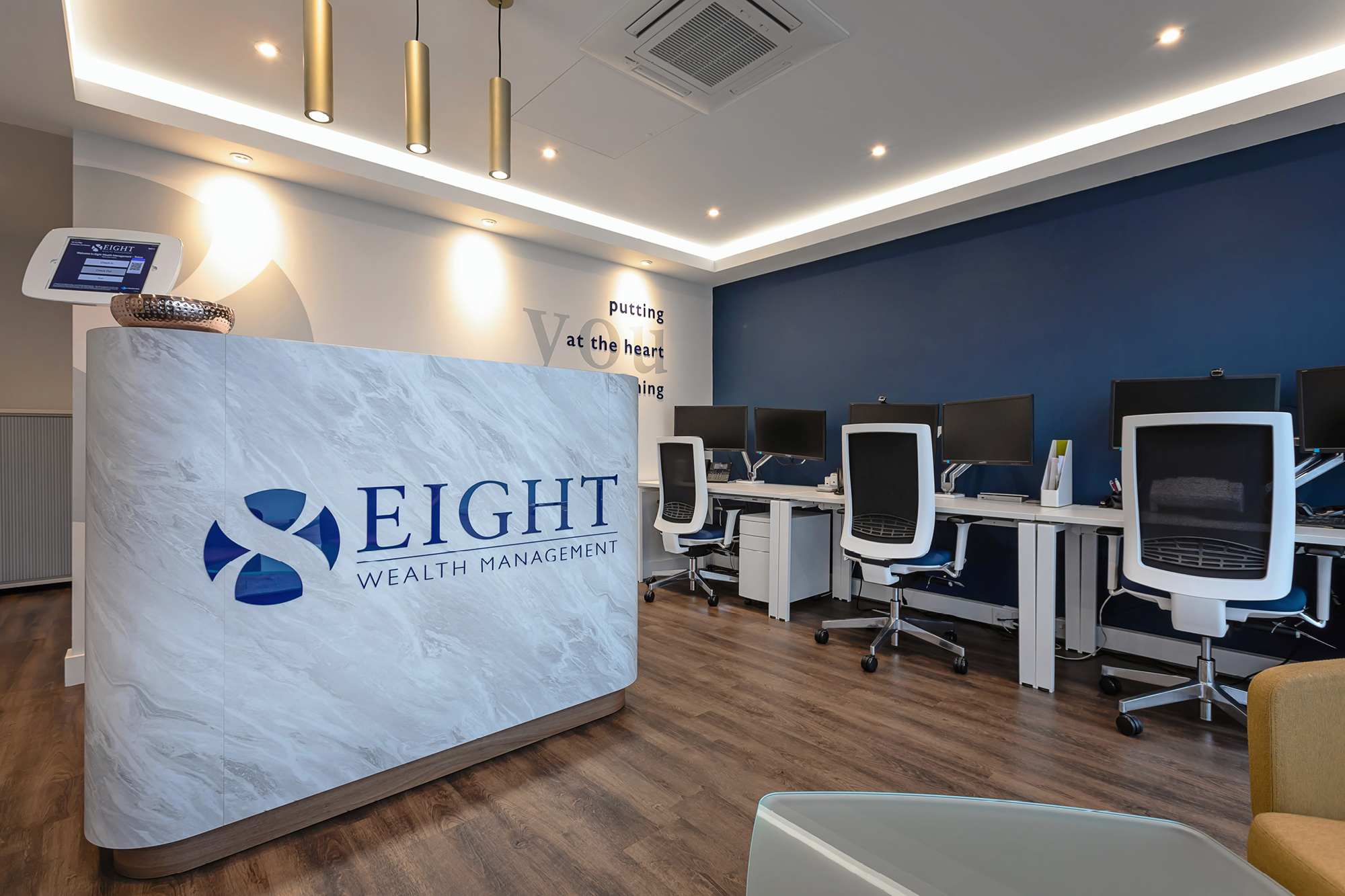 Modern office interior of Eight Wealth Management showing a reception desk with a logo.