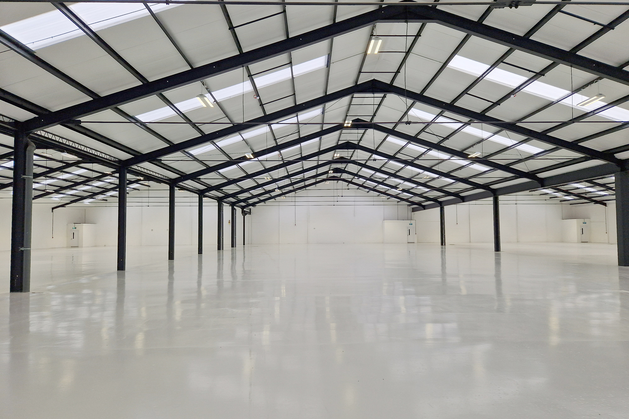 Modern warehouse industrial fit out, clean white floors with black framing.