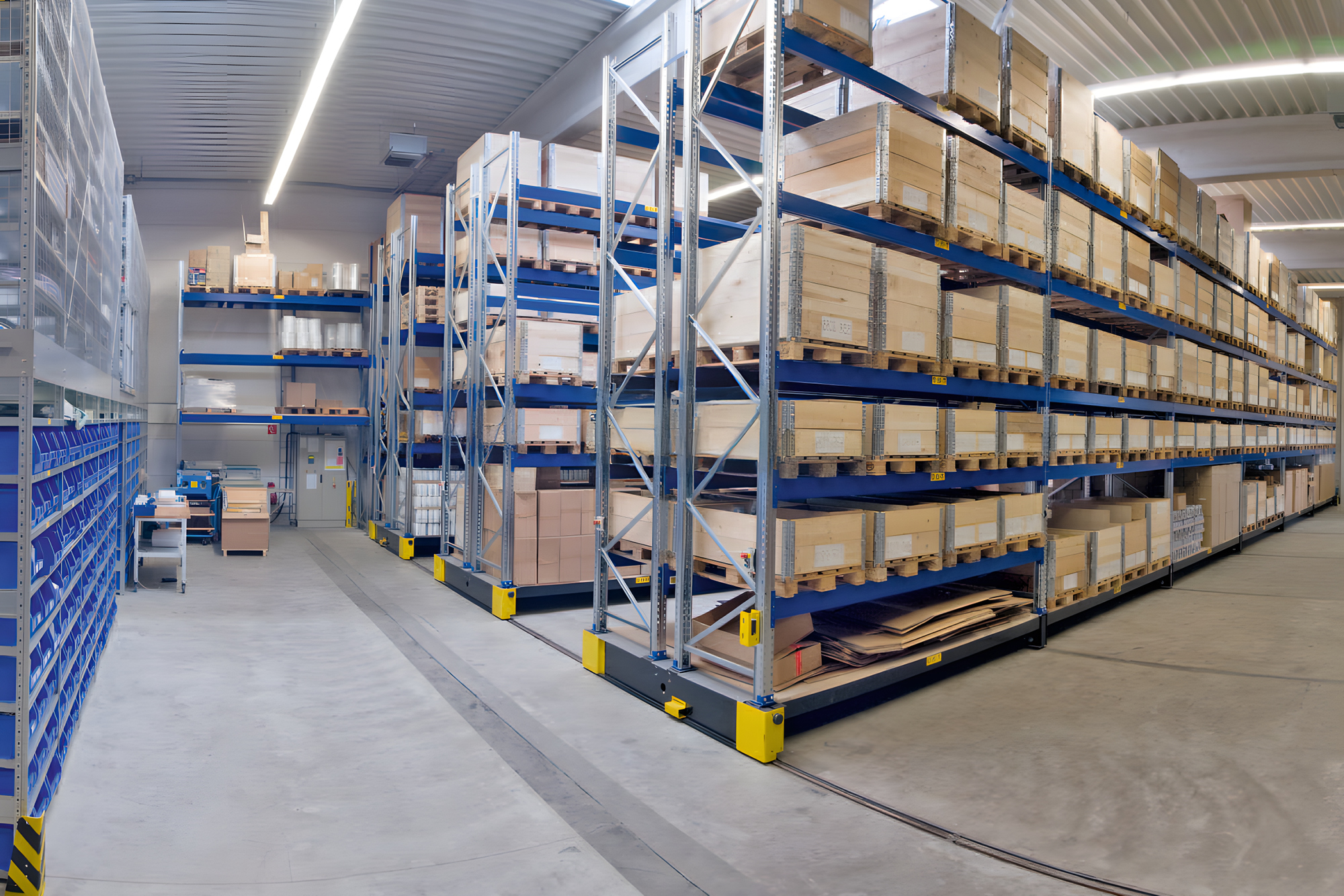 Blue racking system in warehouse with stacked boxes and other warehouse / stationary supplies.