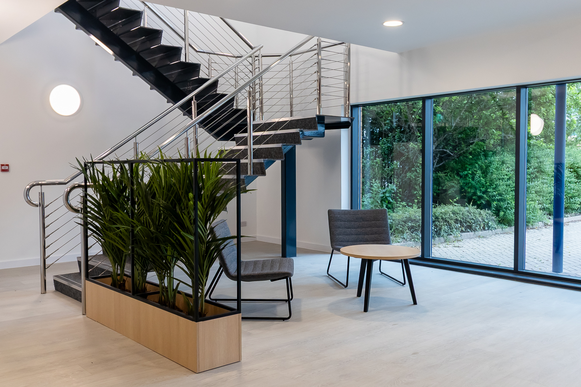 modern stairwell with coffee table and chairs with planters