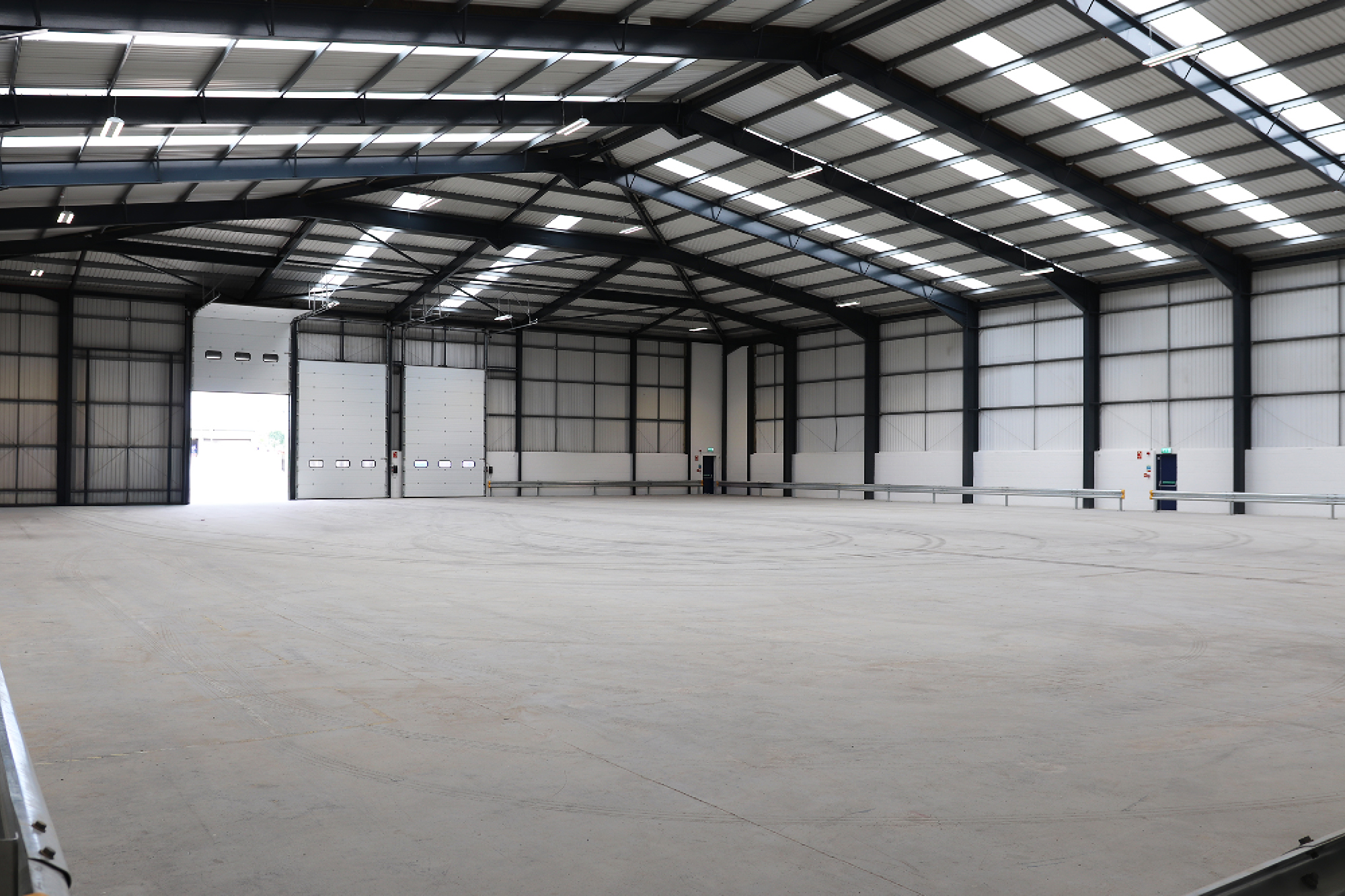 warehouse with led lighting and open door in distance