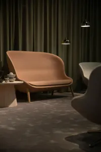 Comfortable brown leather sofa with wooden legs.