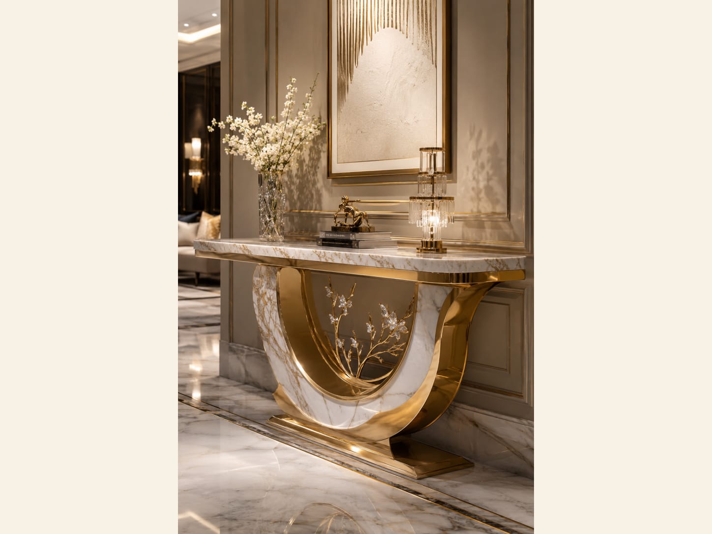 A Gold and Marble Curved Console with Blossom Detailing A glamorous entryway built around a polished gold console with a curved U-shaped base, a white-and-gold marble top, delicate gold blossom branches set into the base, white flowers and a textured gold artwork above.