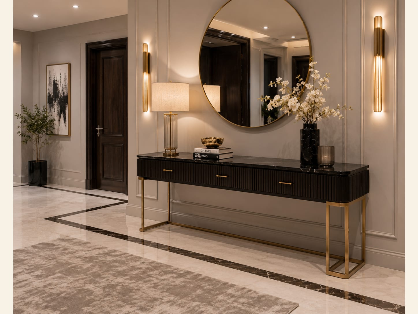 A Black Fluted Console on a Gold Frame with a Round Mirror A black fluted console with a black marble top on a slim gold frame, a large round gold mirror, gold tube sconces, a black marble vase and a black-and-cream marble floor inlay.
