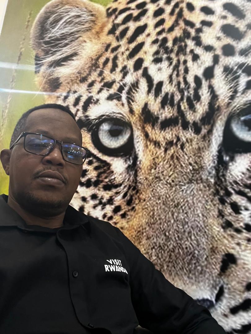 Visit Rwanda representative beside a leopard display