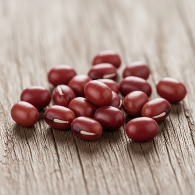 A handful of uncooked Adzuki Bean beans (beans) scattered on a rustic wooden surface, photographed in natural light to emphasize their variety and color