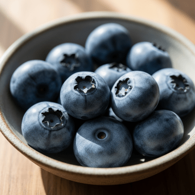 A high resolution image of several fresh Blueberrys arranged in a simple bowl, representing their use within the taxonomy berries