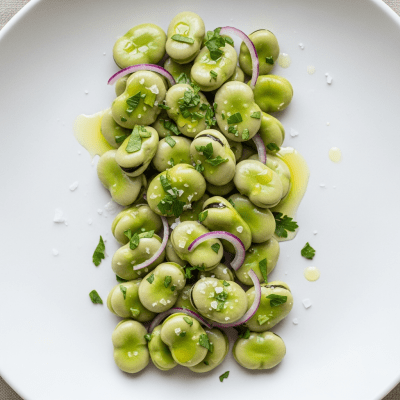 Image of cooked or prepared Faba Bean (legumes) as it appears in a traditional dish or common culinary usage, presented on a clean plate with minimal garnish