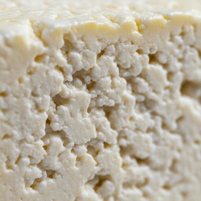 A close-up macro photograph of the rind and surface texture of a Feta