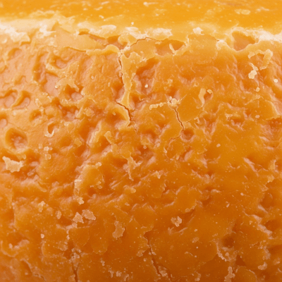 A close-up macro photograph of the rind and surface texture of a Gouda